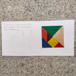 Vista superior de una tarjeta blanca sobre una superficie de granito. En la tarjeta, hay un collage formado formas geométricas en colores primarios y neutros, al estilo de Mondrian. Junto al collage, un texto escrito a mano que dice: "La justicia, cultura, poesía, ves o no ves, las cosquillas. Fíjate Mondrian».