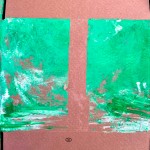 Vista detalle de una obra finalizada. Lateral de una caja de cartón con dos bloques rectangulares pintados en verde (trazo grueso).