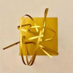 Detalle de una de las creaciones del taller. Sobre una base de cartulina dorada, una escultura de finas láminas del mismo material y color. 