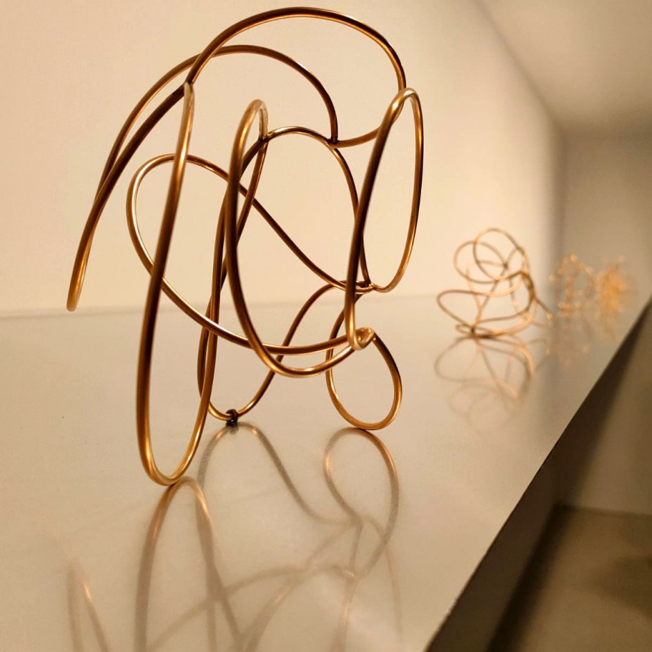 Detalle de la obra 'Atada VIII', de acero inoxidable bañado en oro. La escultura, de pequeña escala, recuerda una maraña de cables entrelazados.