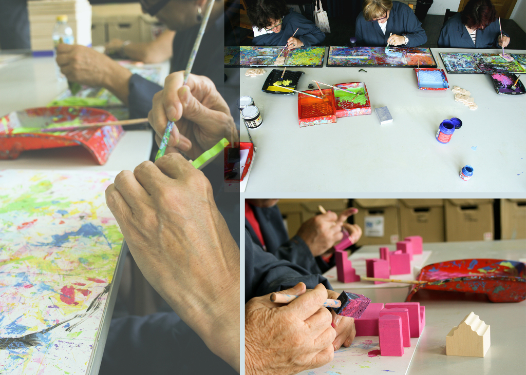 Fases de fabricación de los puzles de Manualia. [Descripción de imagen] Detalle y vista superior de tres mujeres pintando las piezas en diferentes colores.